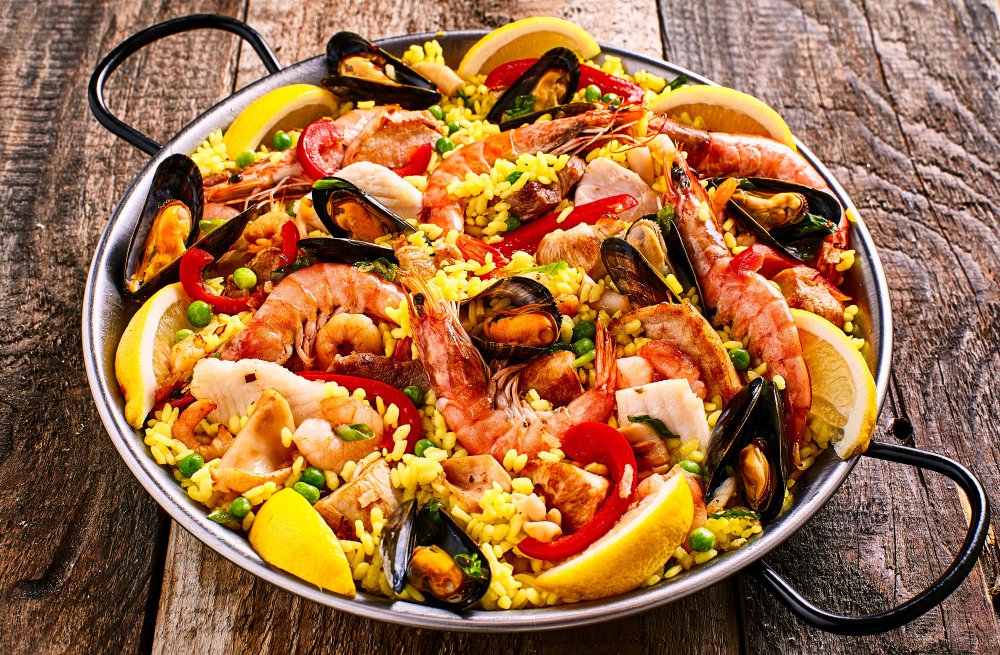 paella dans une grande paellera sur du bois